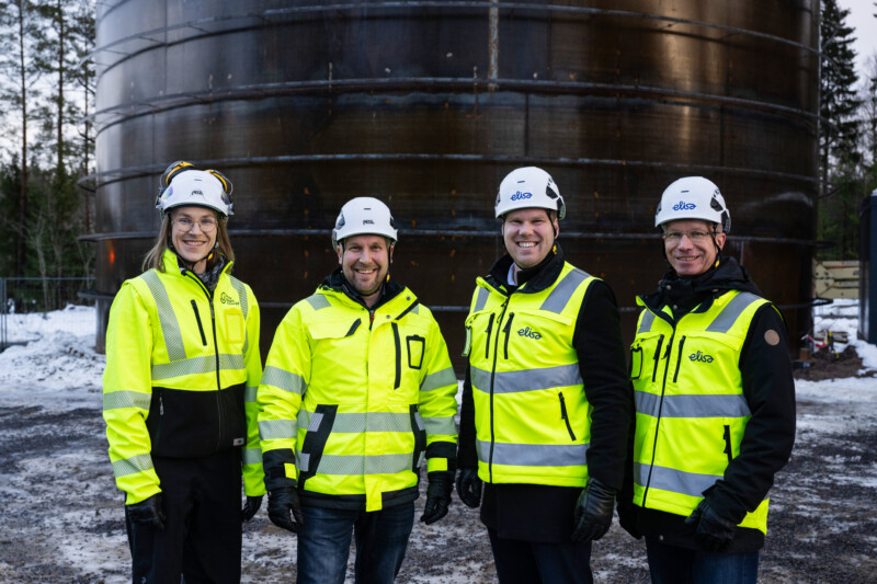 Four people standing in front of the Pornainen Sand Battery.